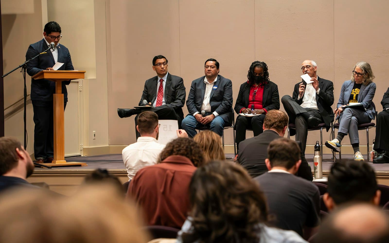Three panellists seated on stage in front of an audience