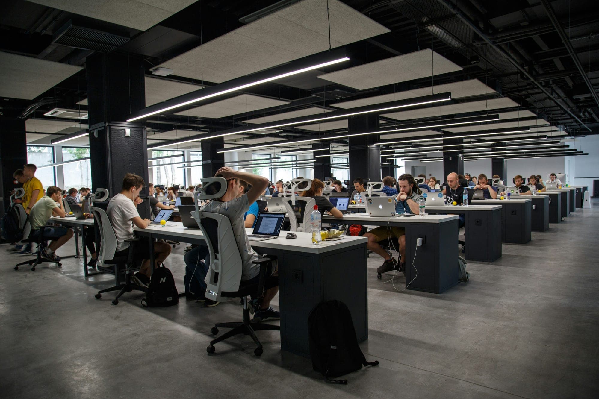 An open-plan office with rows of people working at desks